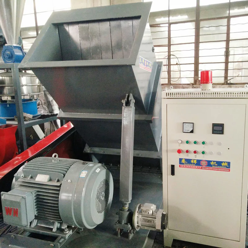 Plastic scrap being fed into a crusher inlet