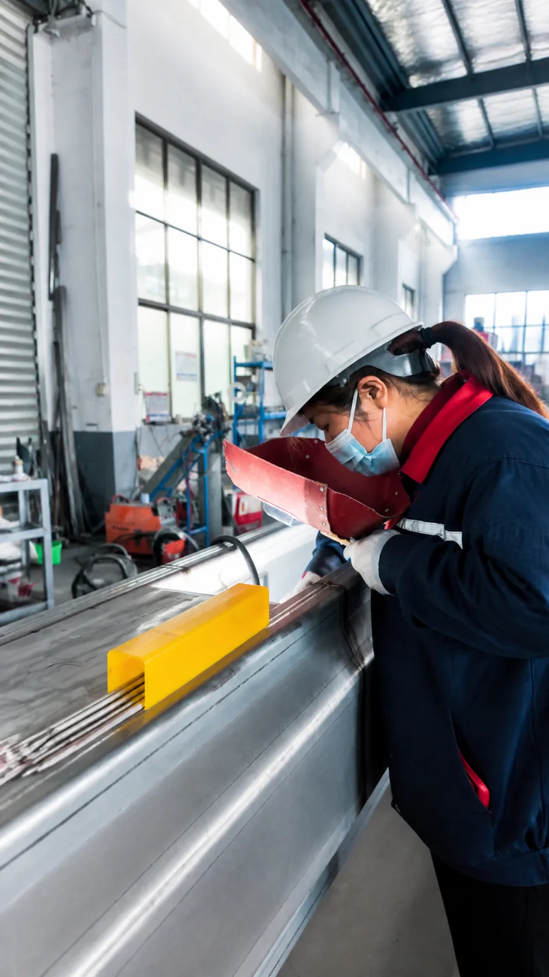 Engineer configuring an extrusion machine setup in the workshop
