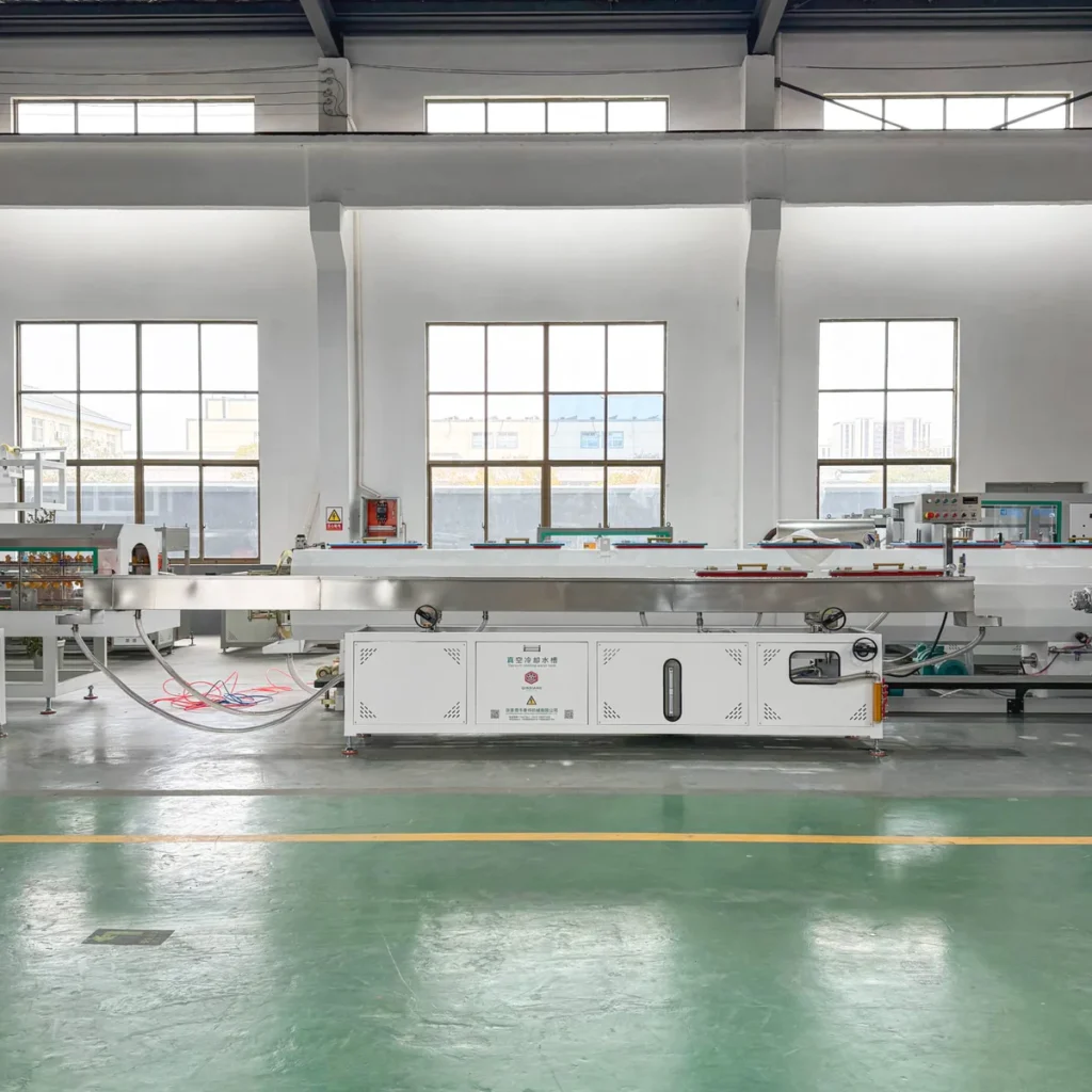 Plastic extrusion machine for manufacturing plastic pipes and profiles in a factory setting